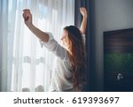Pretty young woman in modern apartment stretching after wake up