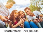 Group of friends sitting together using their mobile phones