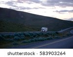 Small photo of Evening highway passes in the hills overgrown with small bushes, on which semi trucks are drawn like ants hardly moving heavy luggage, big rig crawling on protracted climbs Oregon hills.