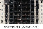 Small photo of A burnt-out high-rise in the war zone. Damage to a residential building as a result of artillery shelling. War in residential areas, broken windows and burned apartments. Armed conflict in Ukraine