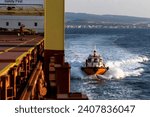 Small photo of Pilot boat and cargo vessel at sea. Pilot embarkation. Pilotage.