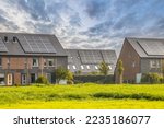 Small photo of Row of modern family houses in contemporary street. New ecological neighborhood with solar panels. Small gardens and private parking places. Street view in Heerhugowaard, Netherlands.