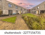 Small photo of Modern living community in the dutch city of Groningen. Contemporary Apartments in residential low rise building exterior. Housing structure with communal garden. Examplary house in Europe.