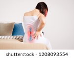 Pain in the spine, woman with backache at home, injury in the lower back, photo with highlighted skeleton