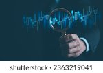 Small photo of Ideas and perspectives, Stock investment stock market for analysis technical graph Businessman hand holding magnifying glass with virtual stock market chart, Business investment earning income concept