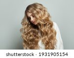 Healthy blonde woman with wavy hair on white background