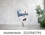 B-Boy performing one handed freeze. Guy breakdancer stands on arm and lifted legs up. Hip hop dance