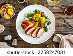 Small photo of Fried pork loin with fried potatoes and vegetables on wooden table