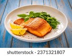 Seared salmon steak with green bean and lemons on wooden table 