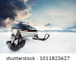 Small photo of Snowmachine on the mountain lake frozen surface with thunderstorm clouds on the background