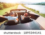 Small photo of Couple in love getting into the convertible auto cabriolet and starting a trip. Couple honeymoon, traveling or vacation concept image.