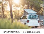 Small photo of Campervan caravan vehicle for van life holiday on mobile home camper mobile motor home. Golden sunshine sneaking through sparse trees of camping. Roof of campervan is covered in colourful sunshine