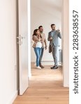 Small photo of Young married couple talking with a real-estate agent visiting apartment for sale or for rent. Future parents buying an apartment. Real estate concept. A new beginning