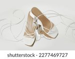 Creative studio shot of white strappy lace up block heel sandals, product photography