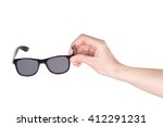 Female hand holding wayfarer sunglasses over white