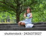 Small photo of A homeless, hungry, abandoned, runaway child looks for food and shelter while holding an empty plate of food