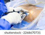 Selective focus with blur background.Surgeon picking up surgical instruments for doctor inside operating room in hospital.Doctor in blue uniform does minimal invasive endoscopic keyhole spine surgery.