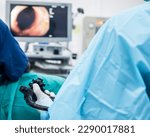 Small photo of A doctor or surgeon in a light blue protective gown did a colonoscopy or gastroscopy inside operating theatre in the hospital.EGD technology for cancer screening.Blur green background and foreground.