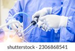 Small photo of Team of doctor or surgeon in blue gown inside operating room in hospital.Surgeon did laparoscopic or endoscopic knee or shoulder orthopedic surgery.Endoscopy of thyroid surgery with light effect.