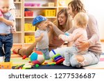 Small photo of Group of young moms with their babies at playgroup