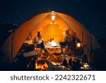 Small photo of Asian couple enjoy in they tent in camping trip on night time with many star on the sky, they enjoy coffee, music, singing and sweet in camp