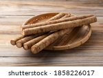 Small photo of Burdock in a bamboo colander placed in the background of a wooden board