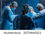 Small photo of Multiracial team of professional medical surgeons performs the surgical operation in a modern hospital. Doctors are working to save the patient. Medicine, health, cardiology and transplantation.