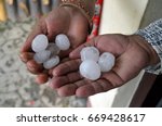 Giant hailstones in hands of two humans.  Chitwan national park, Nepal