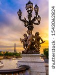 Small photo of Street lantern on the Alexandre III Bridge with the Eiffel Tower in the background in Paris, France. Architecture and landmarks of Paris. Sunset cityscape of Paris