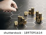 Human hand stacking coins over black background with hexagonal golden shapes. Concept of angel investor and investing in startup companies. Composite image between a hand photography and a 3D backgrou