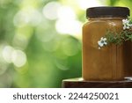 Small photo of Manuka honey and flowers on nature background.