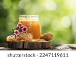 Small photo of Manuka honey and flowers on nature background.
