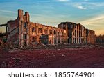 Small photo of Landscape of ruined buildings at sunset, image of decrepitude or natural disaster.