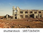 Small photo of Landscape of ruined buildings at sunset, image of decrepitude or natural disaster.