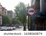 Road sign of United Kingdom for no access to trucks over 7.5 tonnes weight in street of London. Cars parked at city road