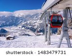 Red Cable cars of Zillertal Arena ski resort in Tyrol in Mayrhofen in Austria at winter Alps. Chair lifts in Alpine mountains with white snow and blue sky. Downhill fun at Austrian snowy slopes.