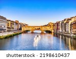 Golden Sunset over Ponte Vecchio Bridge with Traditional Boat on the Arno River, Florence, Italy 