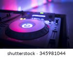 Small photo of DJ console cd mp4 deejay mixing desk Ibiza house music party in nightclub with colored disco lights.