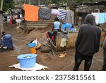 Small photo of NAIROBI SLUM KIBERA, KENYA, AFRICA - NOVEMBER 18, 2022: Women wash and hang laundry in the slums of Nairobi.