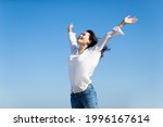 asian Young Woman Cheering Open Arms with isolated sky blue background