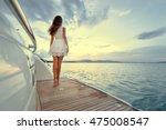 Luxury travel on the yacht. Young woman enjoying the sunset on boat deck sailing the sea.