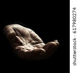 Small photo of Old man asking for support with outstretched hand with wrinkles on the black background. The concept of infirmity and lack of money and food in the elderly people without sufficient social assistance.