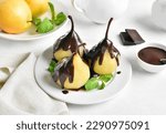 Small photo of Poached pears with chocolate sauce on plate on white background. Close up view
