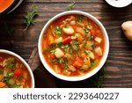 Small photo of Cabbage soup in bowl over wooden background. Top view, flat lay