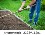 Small photo of Farmer cultivating land in the garden with hand tools. Soil loosening. Gardening concept. Agricultural work on the plantation.