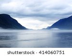 Morning norwegian landscape with mountains and mist over the lake