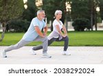 Small photo of Energize your morning. Full length of active happy elderly family couple in sportswear working out together in city park in morning. Joyful senior husband and wife making sport outdoors, warming up