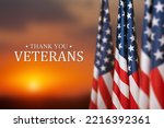 American flags with Text Thank You Veterans on sunset background.