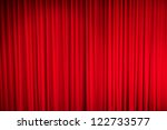 Red closed curtain with light spots in a theater