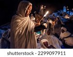 Small photo of Lalibela, Ethiopia - January 7, 2018: Pilgrims praying with candles lit at night outside the Biete Medhane Alem (House of the Saviour of the World) in Lalibela, Ethiopia.